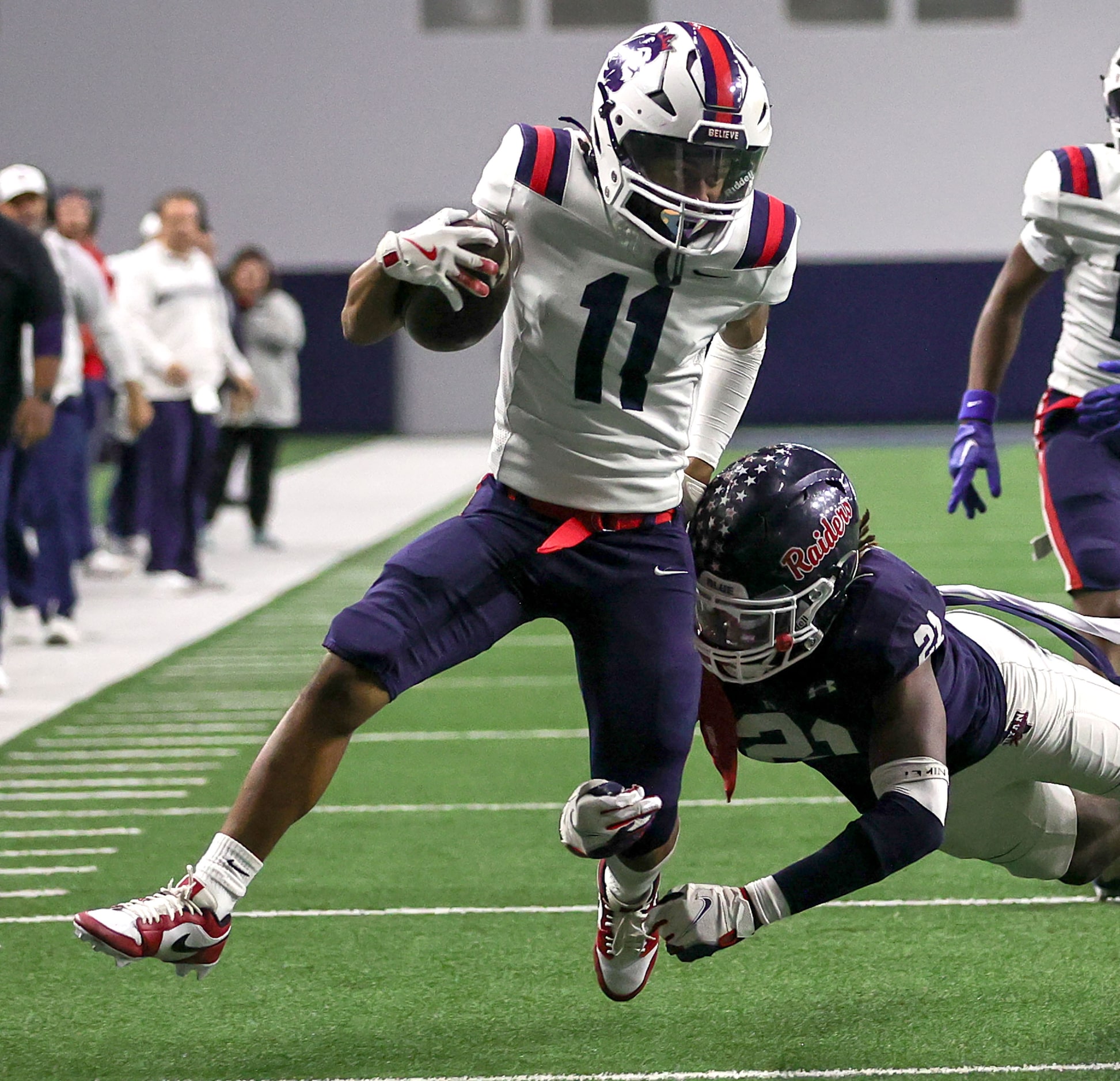 Richland wide receiver Aaron Brooks (11) tries to break a tackle from Denton Ryan linebacker...