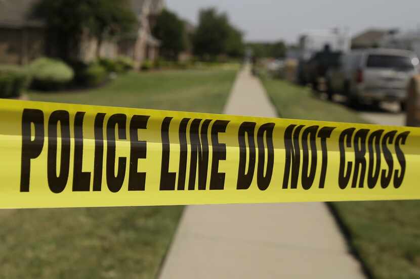 Crime scene tape marks off the area law enforcement investigators are working outside the...