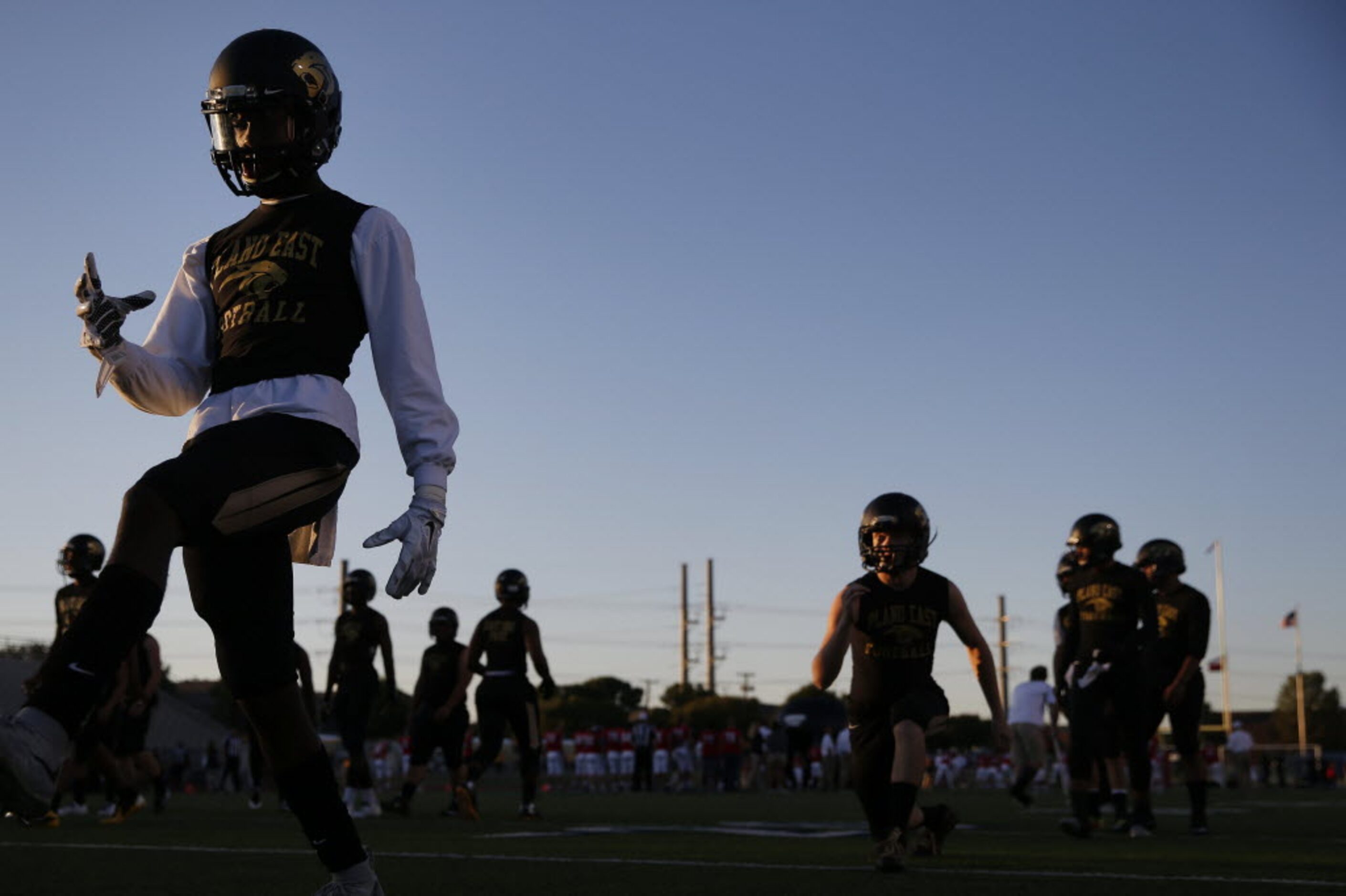 Plano East players stretch before a high school football game between Plano East and...