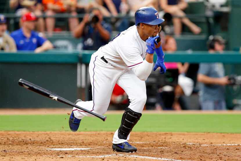 Texas Rangers batter Carlos Gomez (14) flips his bat as he drives in two runs on a single to...