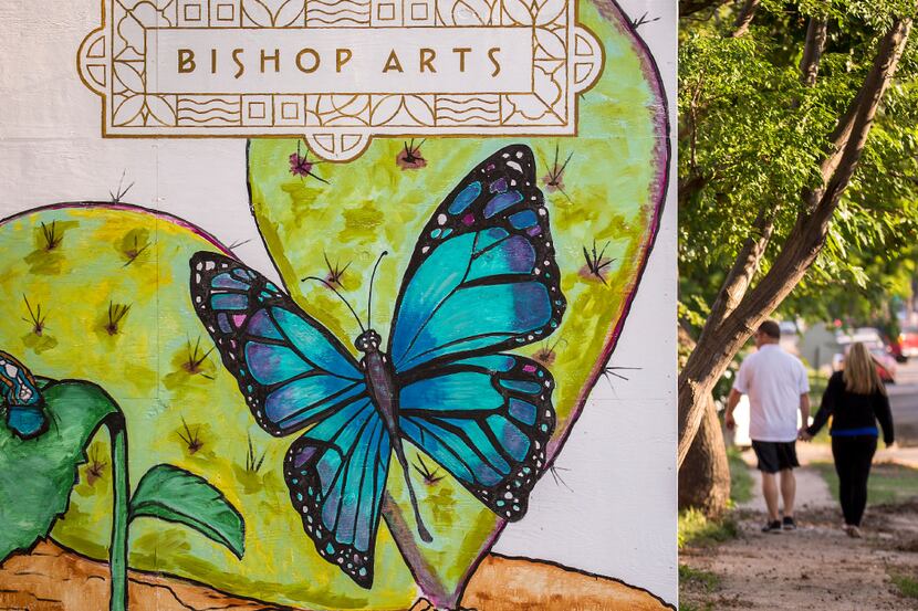 Pedestrians walk past a temporary installation of paintings of flora and fauna at Bishop and...