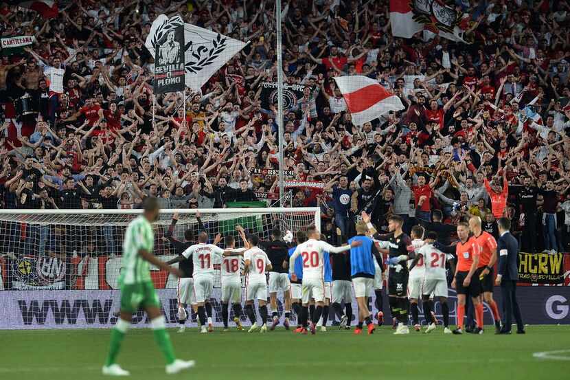 Sevilla's players celebrate with fans at the end of the Spanish league football match...