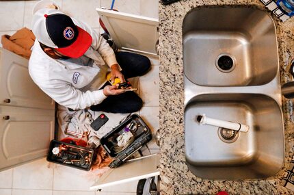 Plumber Geovanni 'Geo' Marino of Baker Brothers Plumbing prepares to sweat a copper...