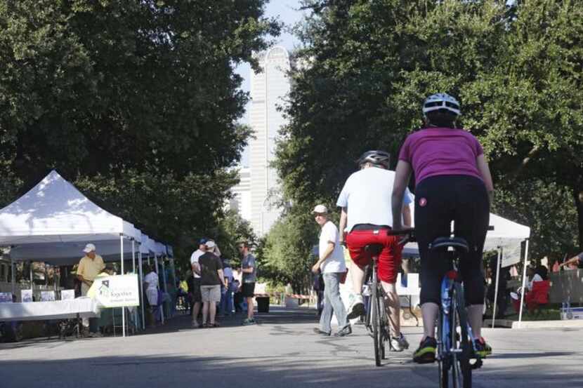 
Cyclists ride down Swiss Avenue toward booths for a city of Dallas neighborhood block party...