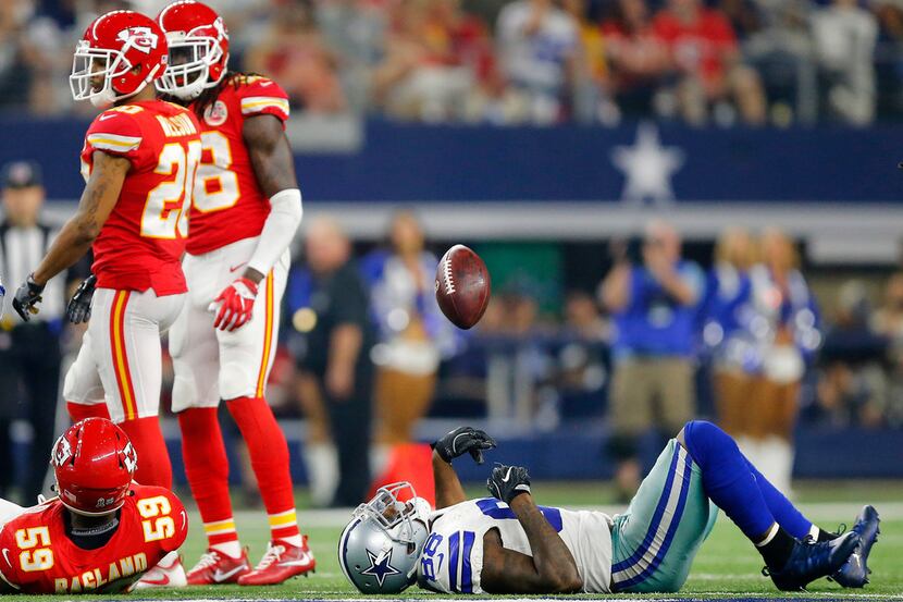 Dallas Cowboys wide receiver Dez Bryant (88) tosses the football as he lies on the field...