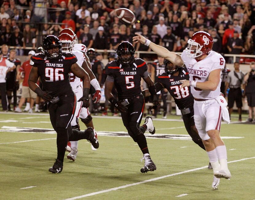 Oklahoma's quarterback Baker Mayfield passes under heavy pursuit by Tech. Texas Tech in an...