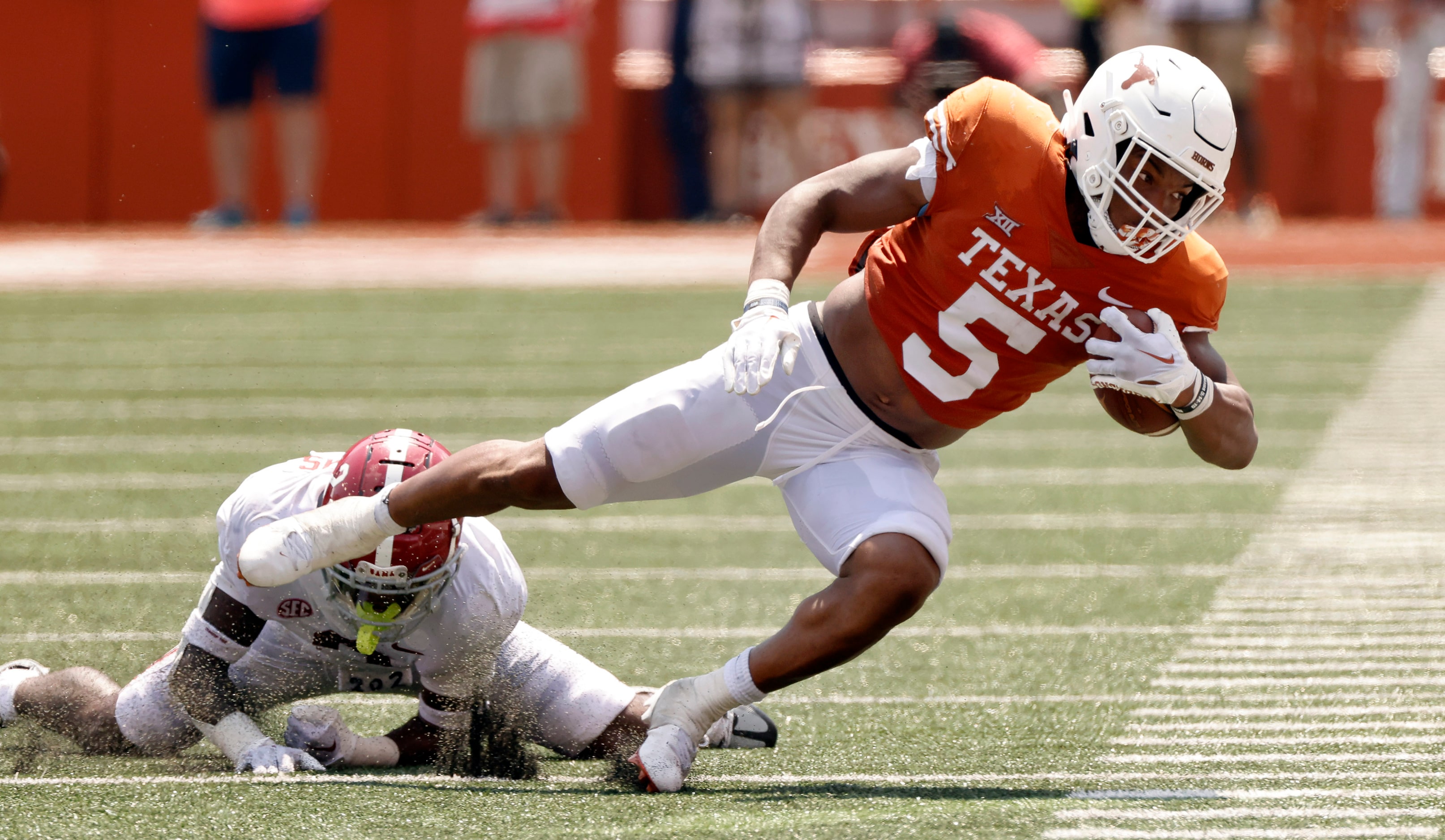 Texas Longhorns running back Bijan Robinson (5) dives toward the sideline after being...