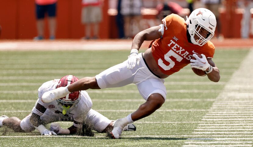 Texas Longhorns running back Bijan Robinson (5) dives toward the sideline after being...