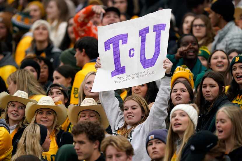 A lone TCU fan in sea of Baylor fans holds up a sign during the first half of an NCAA...