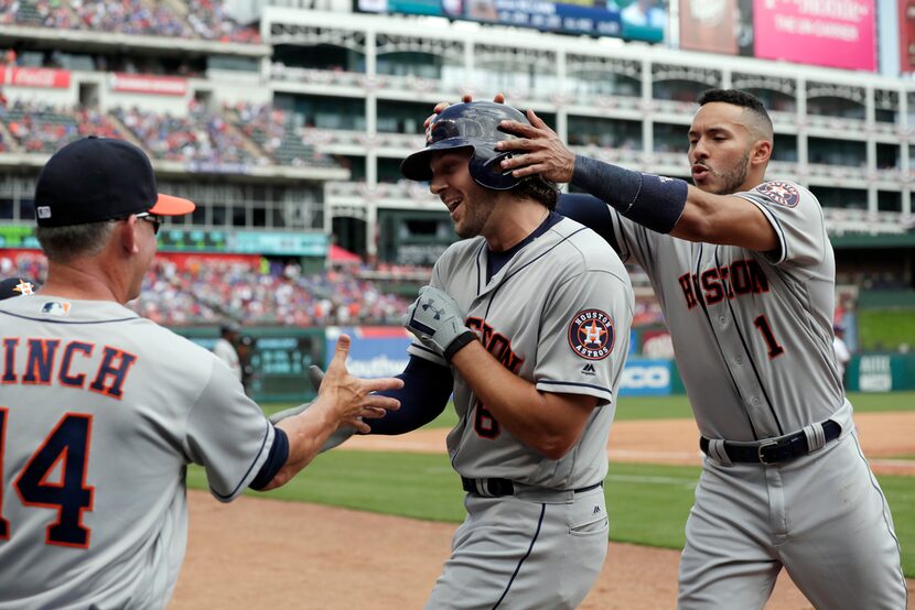 AJ Hinch (14) y Carlos Correa (1) felicitan a Jake Marisnick por su jonrón. (AP Photo/Tony...