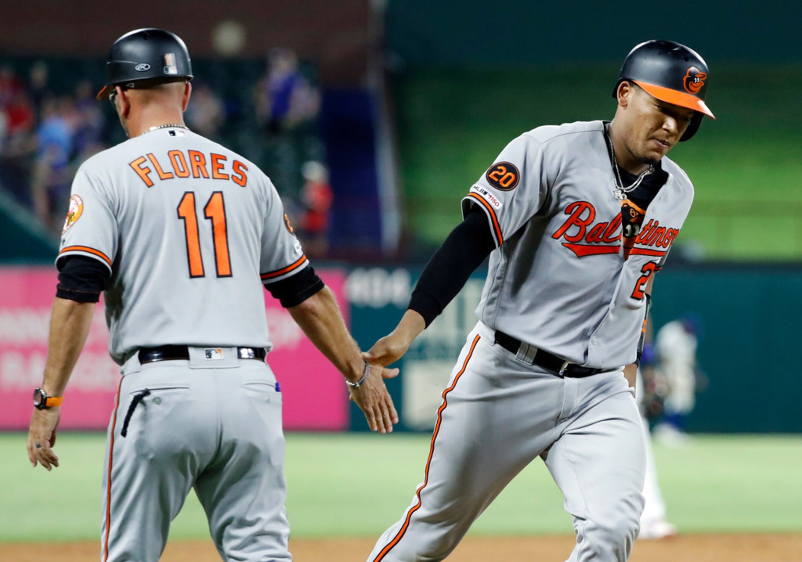 Baltimore Orioles third base coach Jose David Flores (11) congratulates Pedro Severino,...