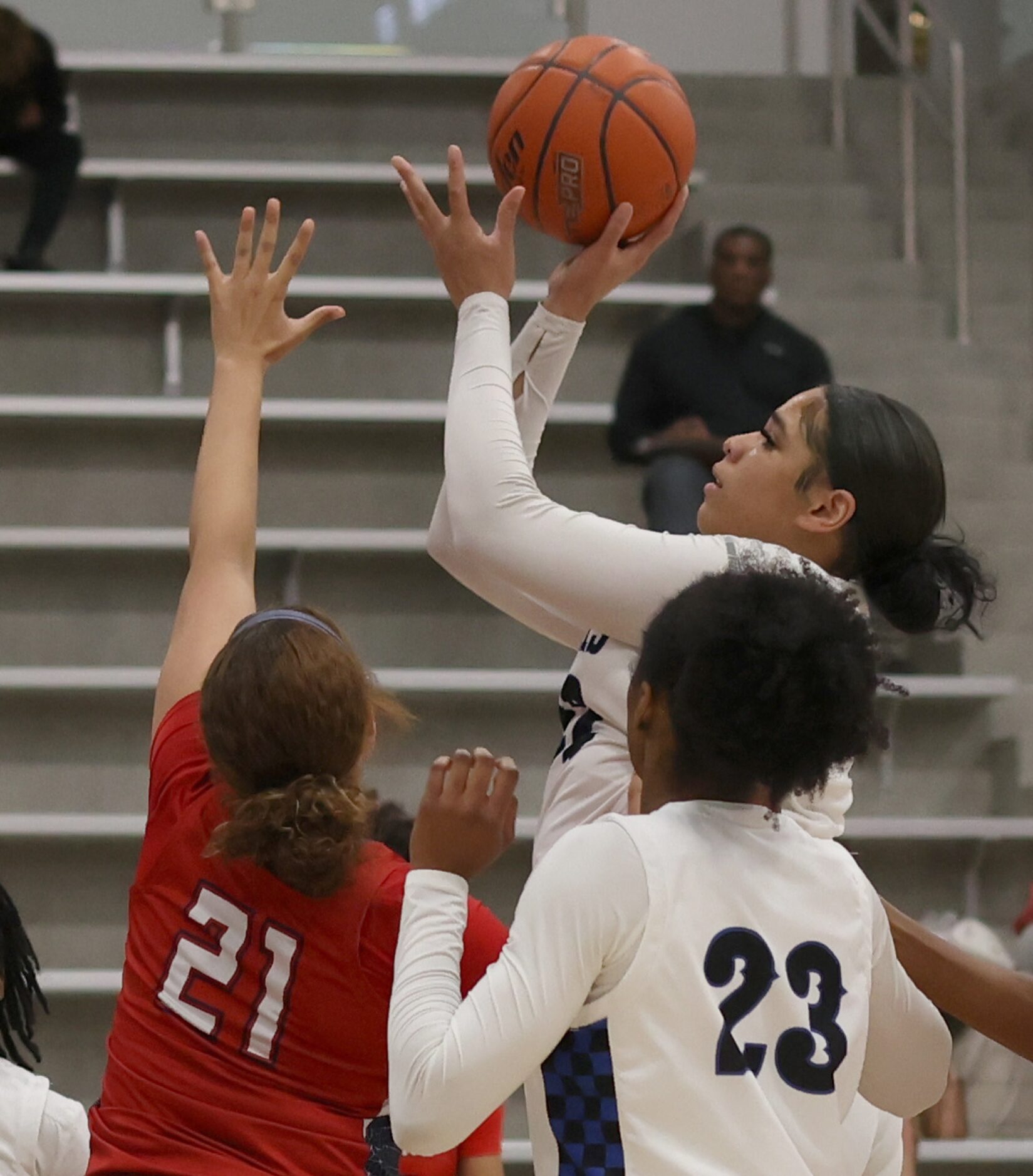 Hebron center Jordan Thomas (22) puts up a shot as she is defended by Denton Ryan forward...