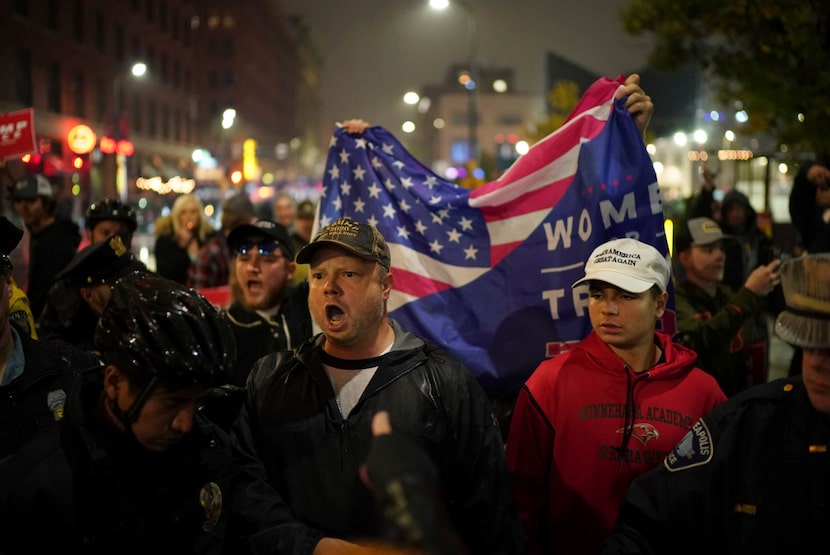 Supporters of President Donald Trump yell at protesters after Trump's campaign rally,...