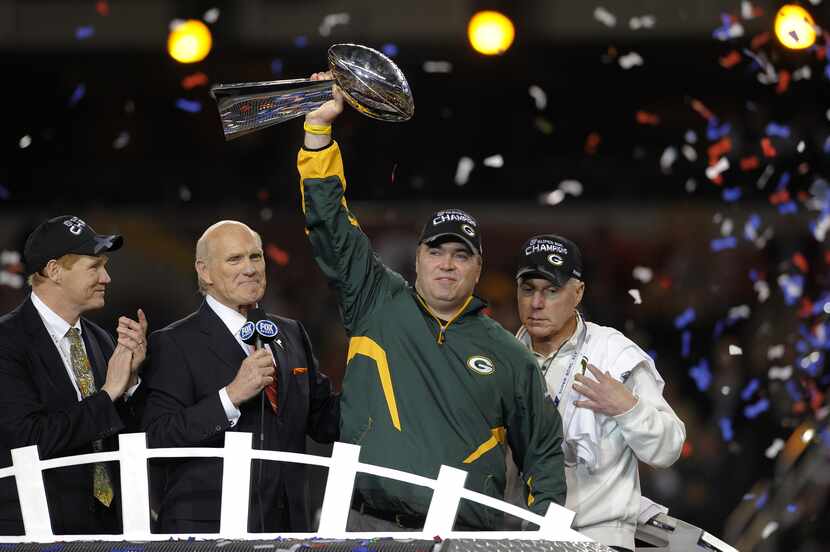 Green Bay Packers head coach Mike McCarthy held the trophy after the Packers defeated the...