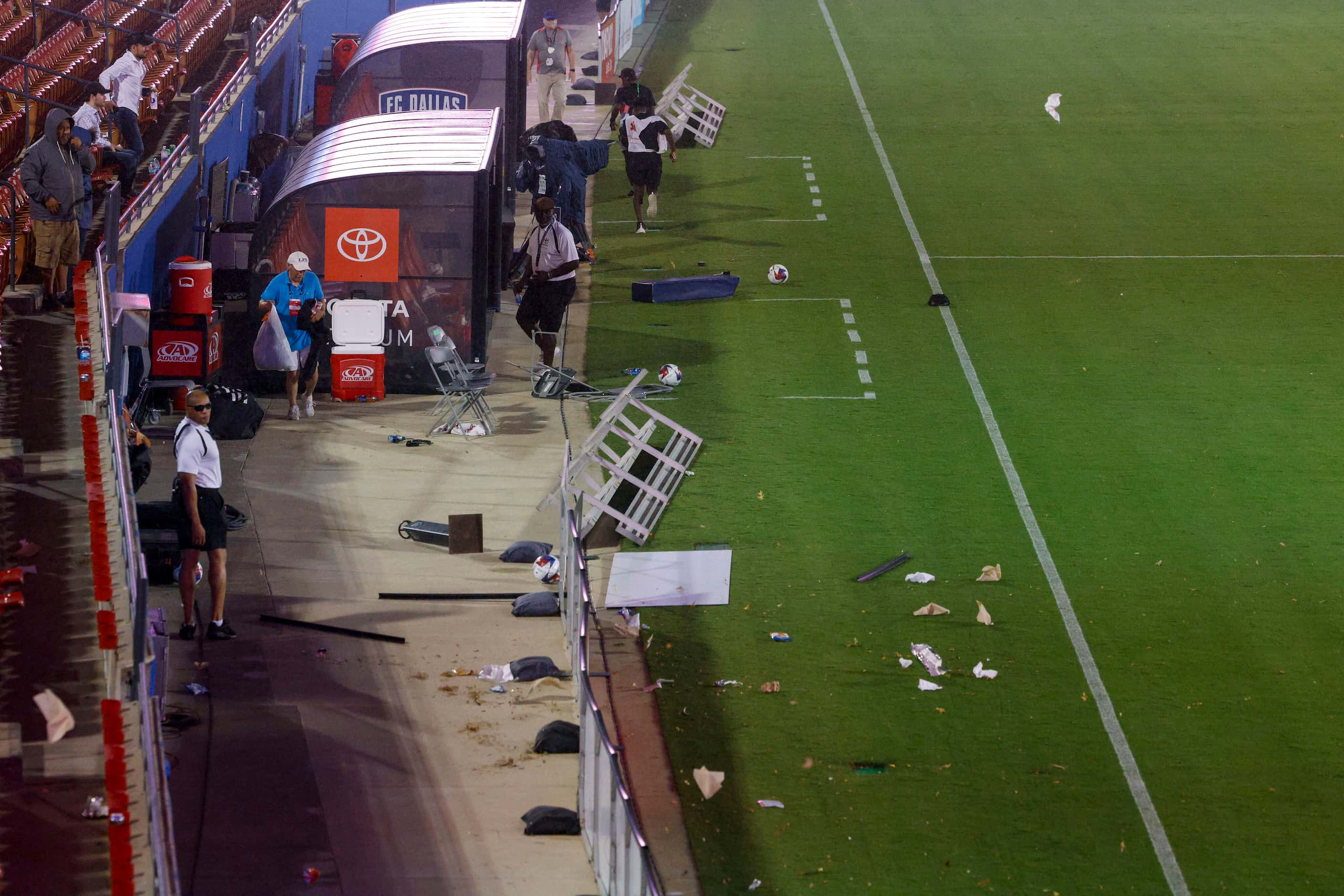 Strong winds blow trash and debris onto the field as a severe thunderstorm moves in during a...