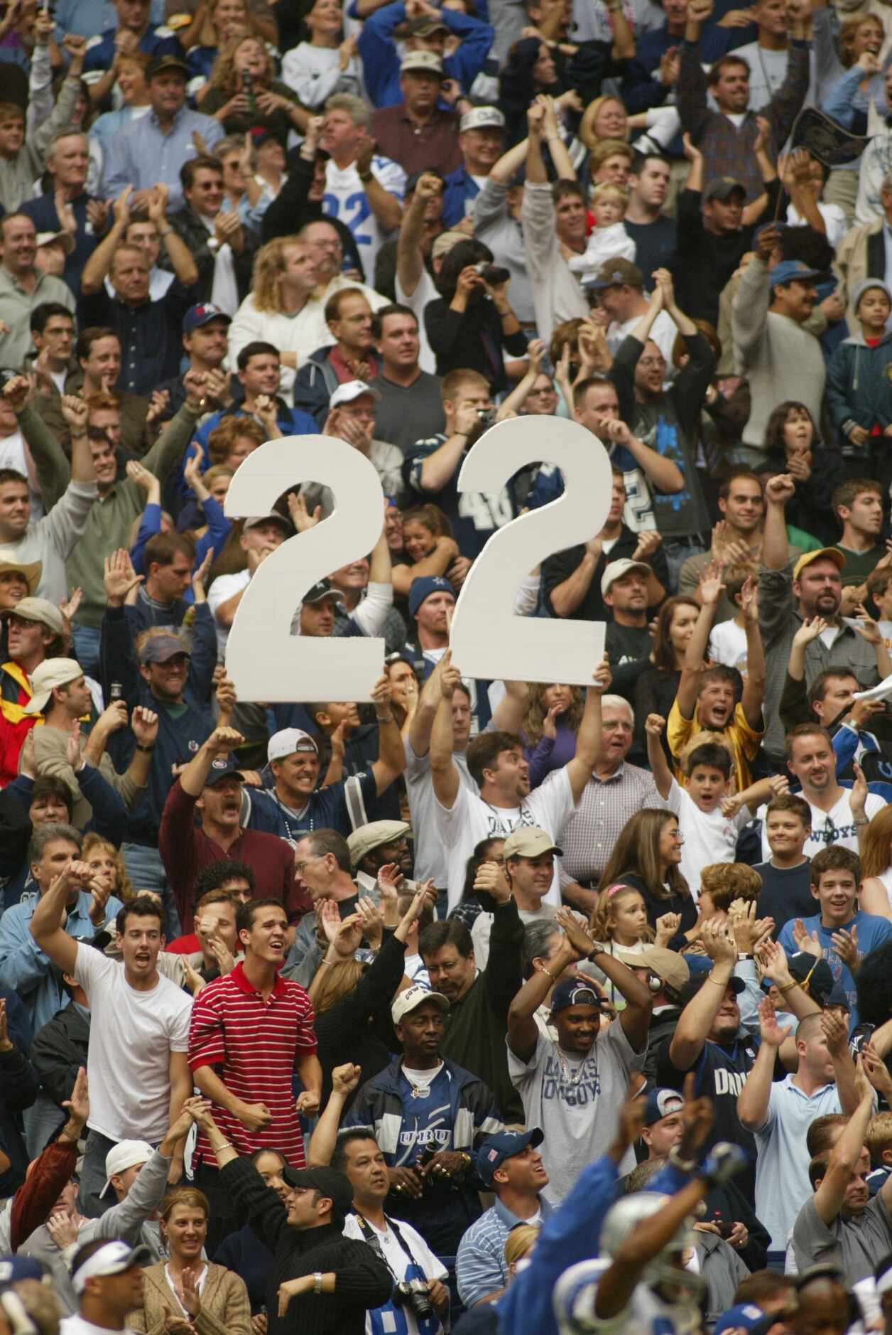 Fans in the stands hold up no. 22 to honor Emmitt Smith’s all-time career rushing record...