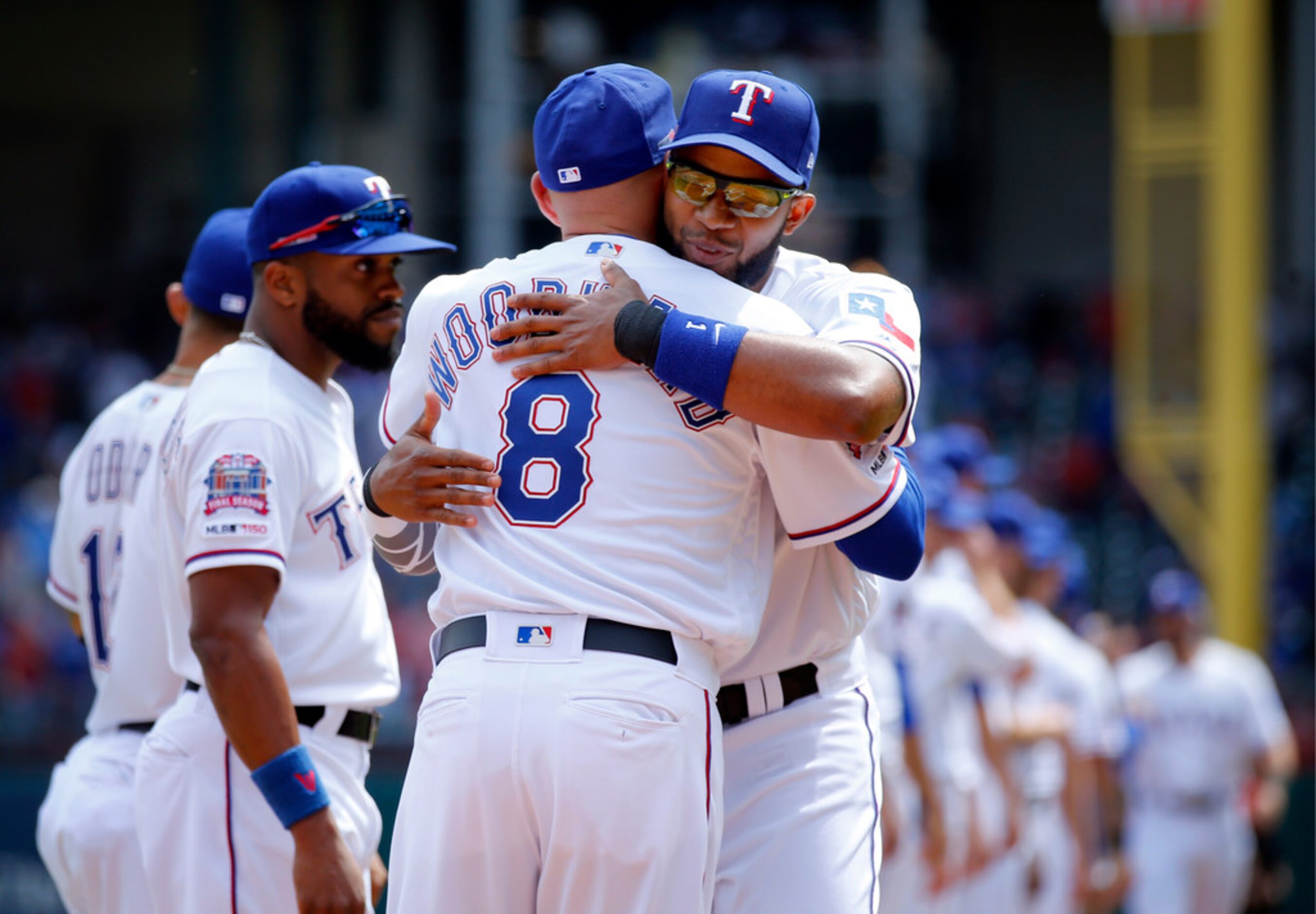 Texas Rangers manager Chris Woodward (8) gives shortstop Elvis Andrus a hug during player...