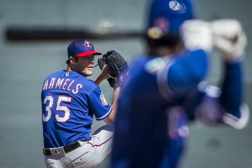 Texas Rangers pitcher Cole Hamels pitches to infielder Pedro Ciraco during a spring training...