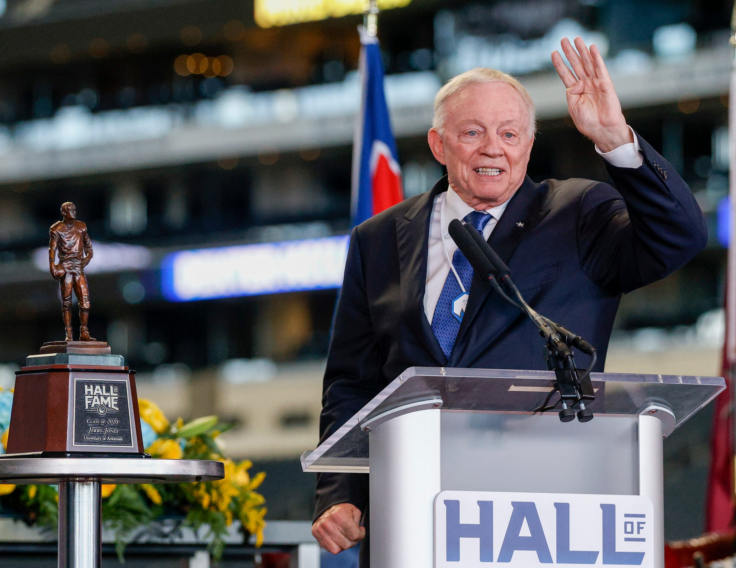 Dallas Cowboys owner Jerry Jones raises four fingers while talking about the fourth quarter...