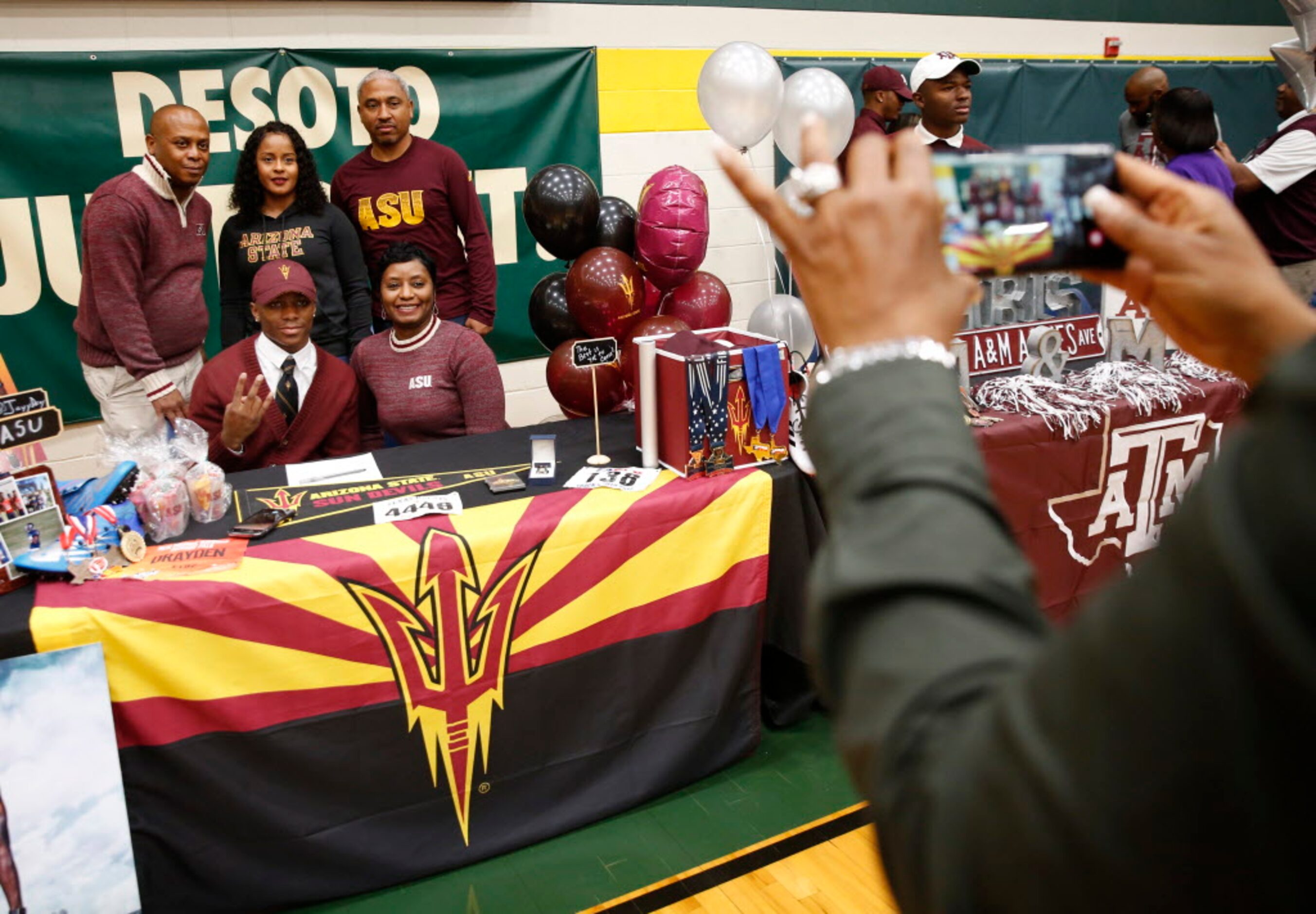 Track athlete Jalen Drayden poses for a photograph with his family after signing with...