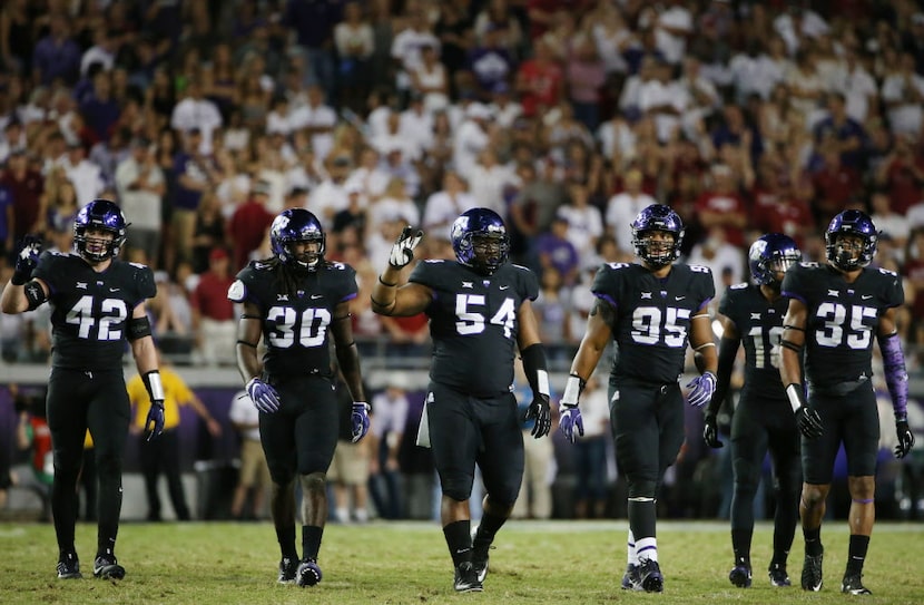 TCU players between plays during an NCAA football game between the Arkansas Razorbacks and...