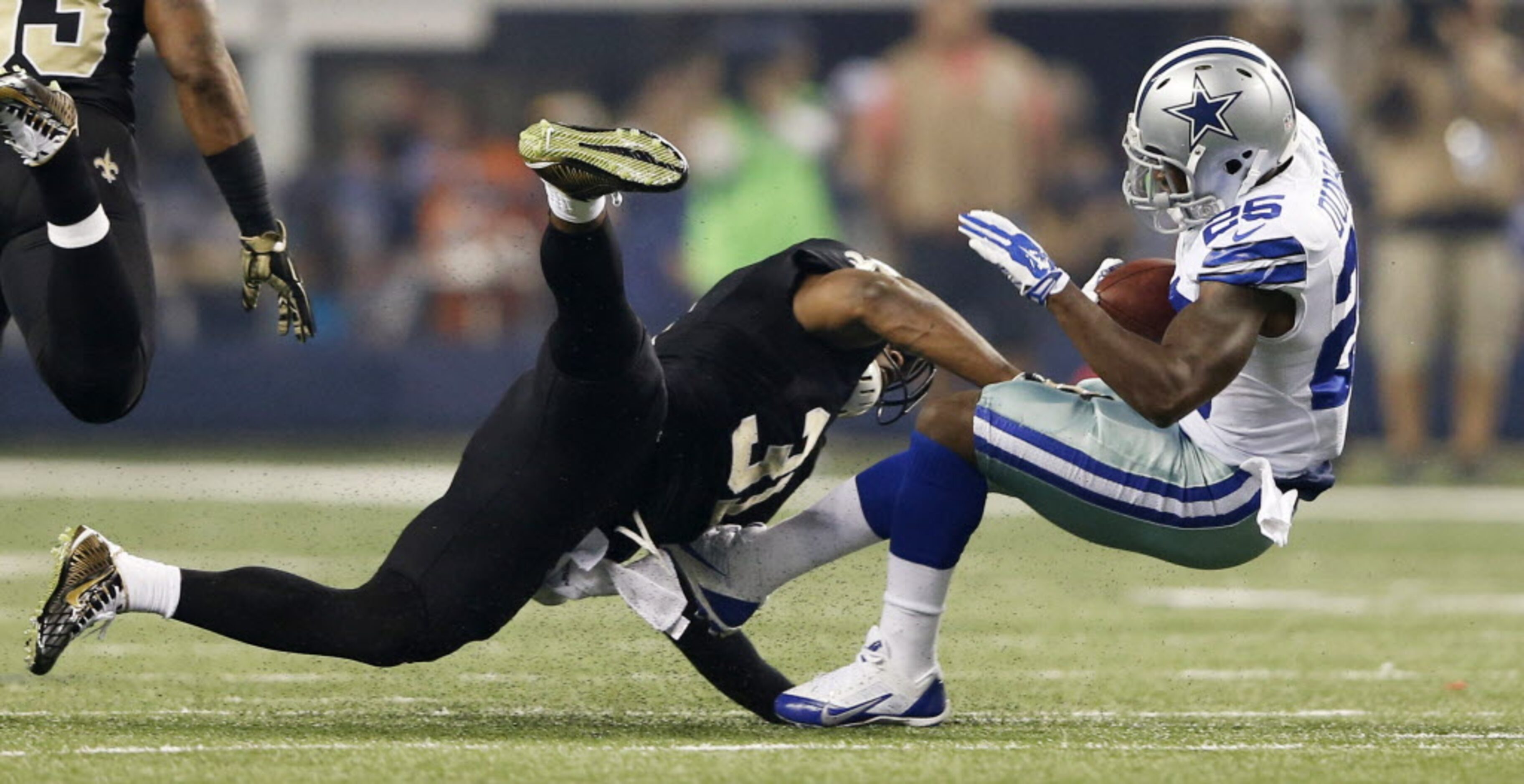 Dallas Cowboys running back Lance Dunbar (25) is hit by New Orleans Saints free safety...