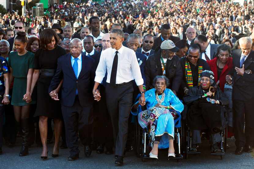 President Barack Obama, center, holds hands with Rep. John Lewis, D-Ga., left, and Amelia...