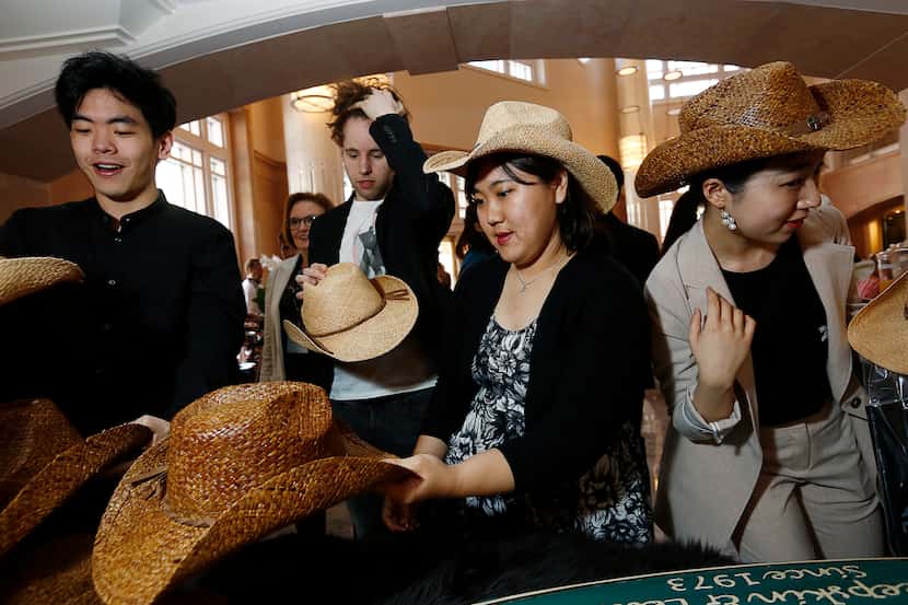 Competitors try on cowboy hats at the competitor orientation for The Fifteenth Van Cliburn...
