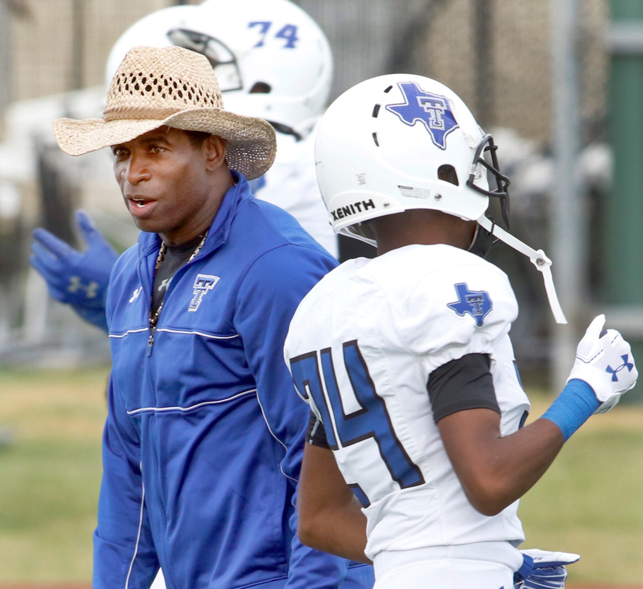 Trinity Christian-Cedar Hill offensive coordinator Deion Sanders oversees his offense as...