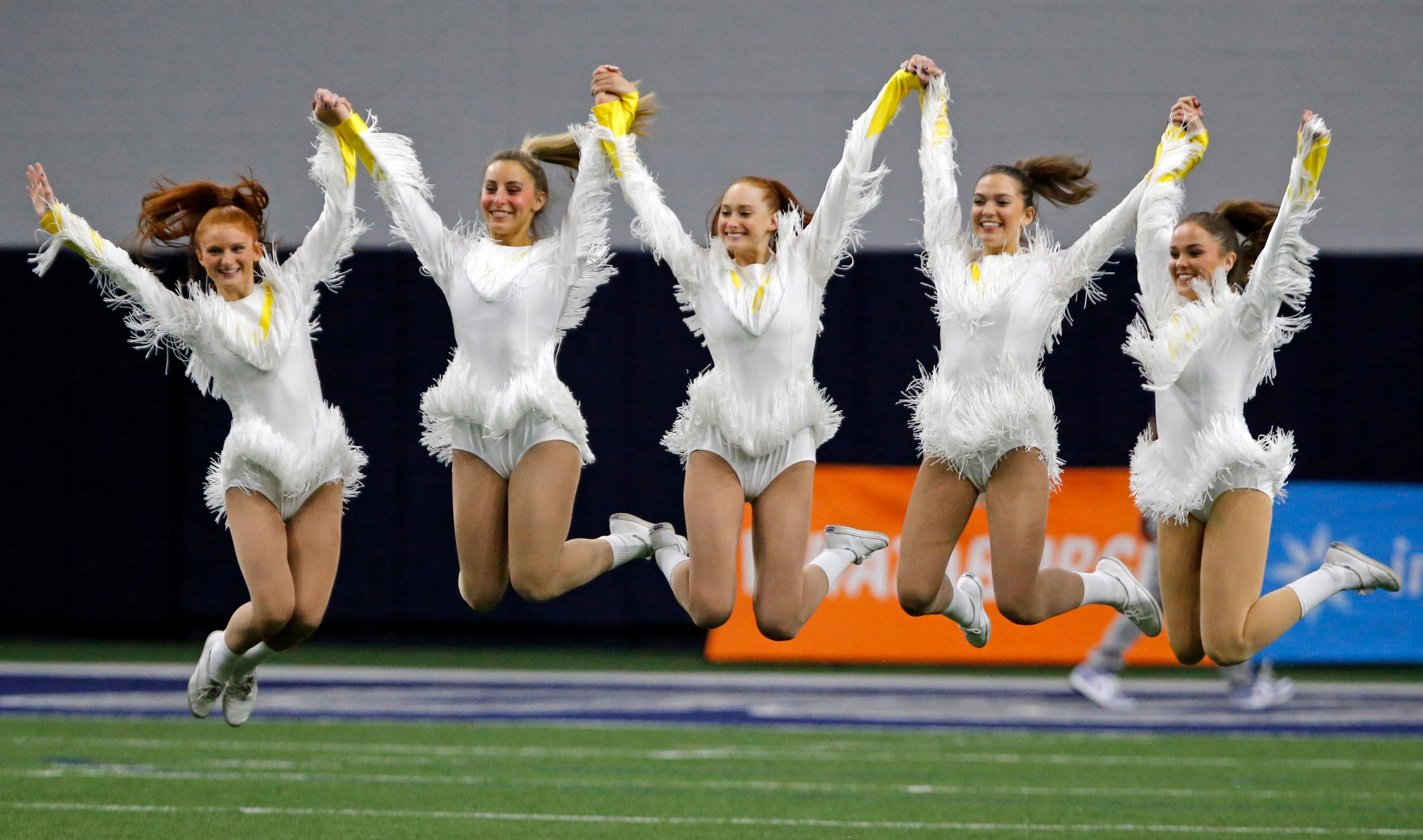 Highland Park students leap high for a photographer before the start of the first half of a...