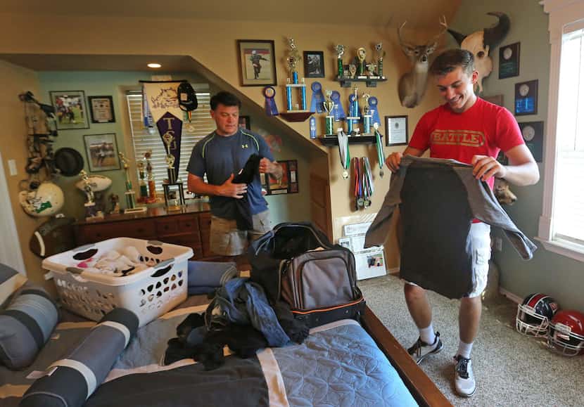 High school quarterback Ken Seals packs his bags for an upcoming football camp in Minnesota,...