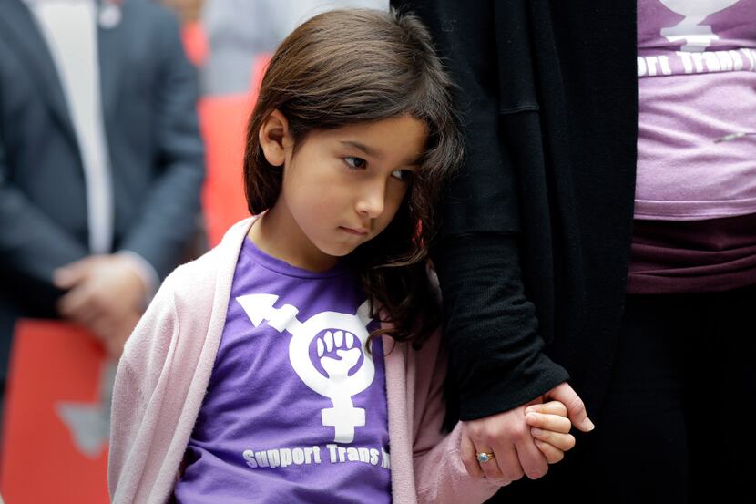 Libby Gonzales, a transgender girl, stands with her mother, Rachel, as members of the...