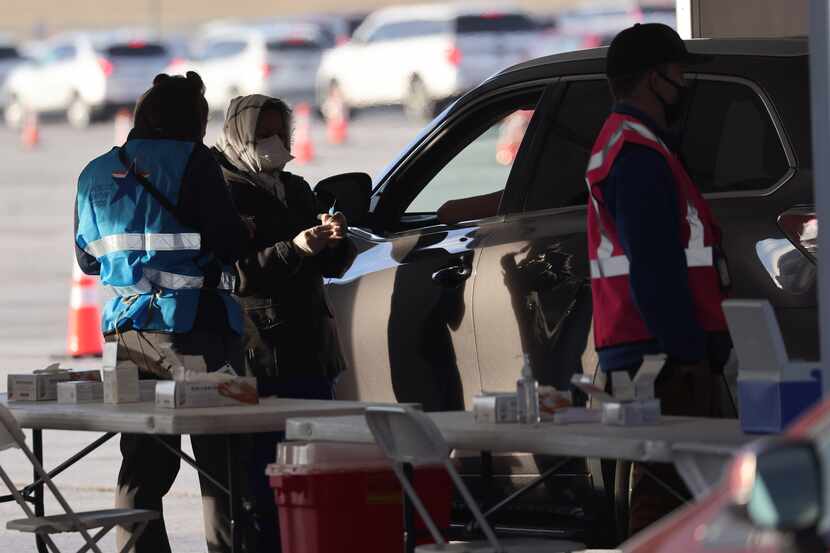 Denton County medical personnel give COVID-19 vaccine shots at a drive-through vaccination...