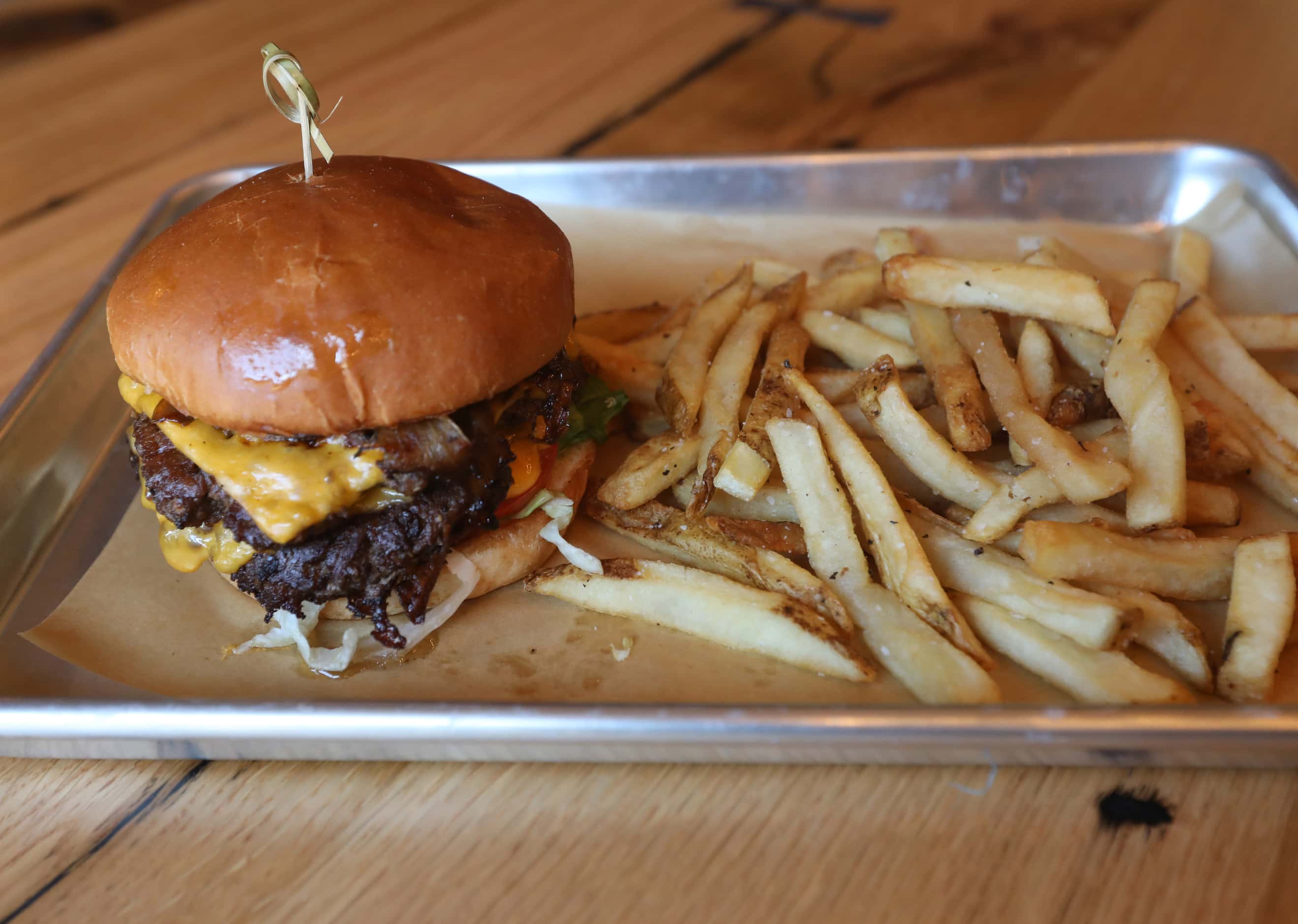 The All-American Wagyu burger with caramelized onion, American cheese, Armor dressing,...