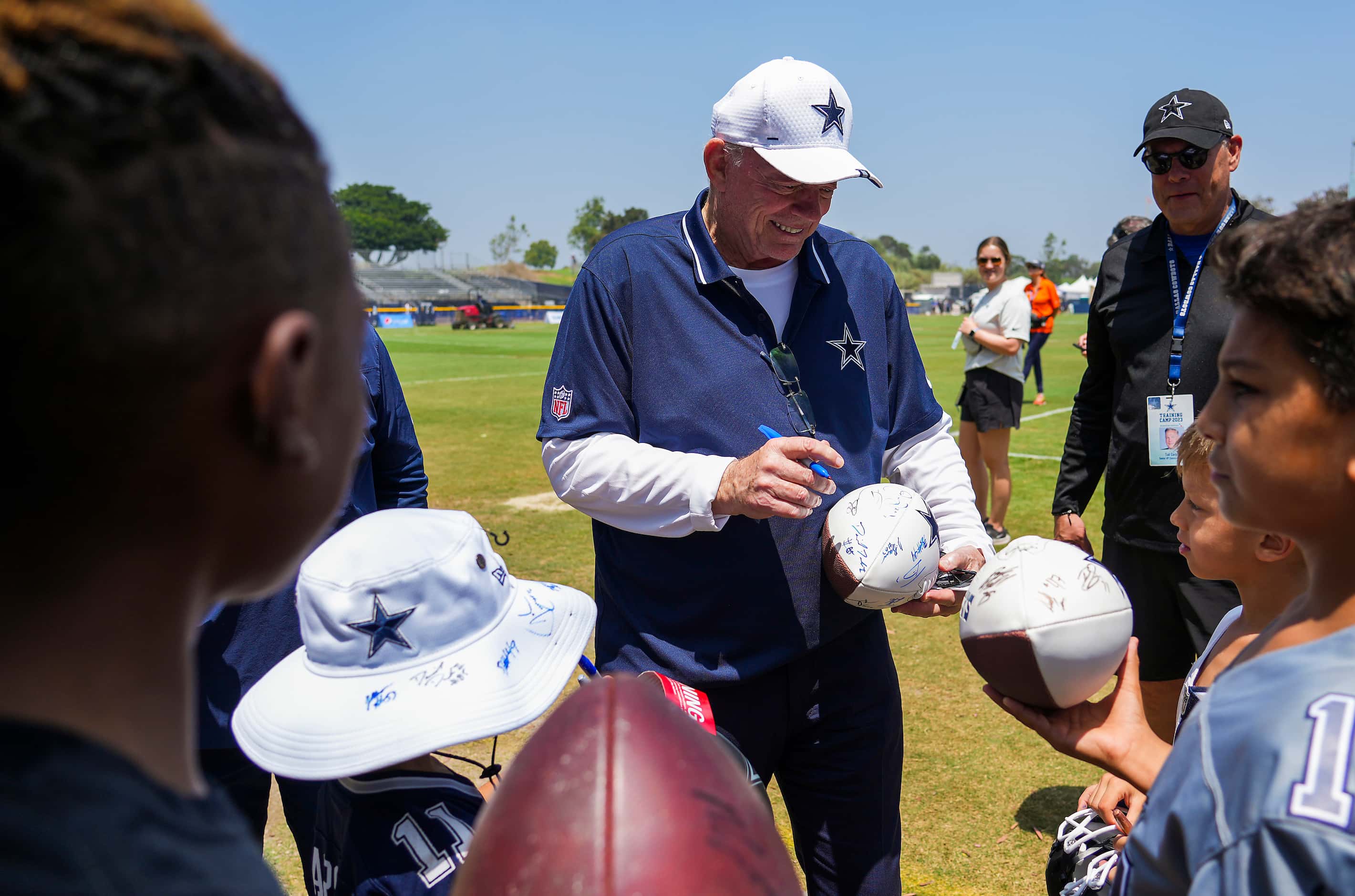 Dallas Cowboys owner and general manager Jerry Jones signs autographs after a training camp...