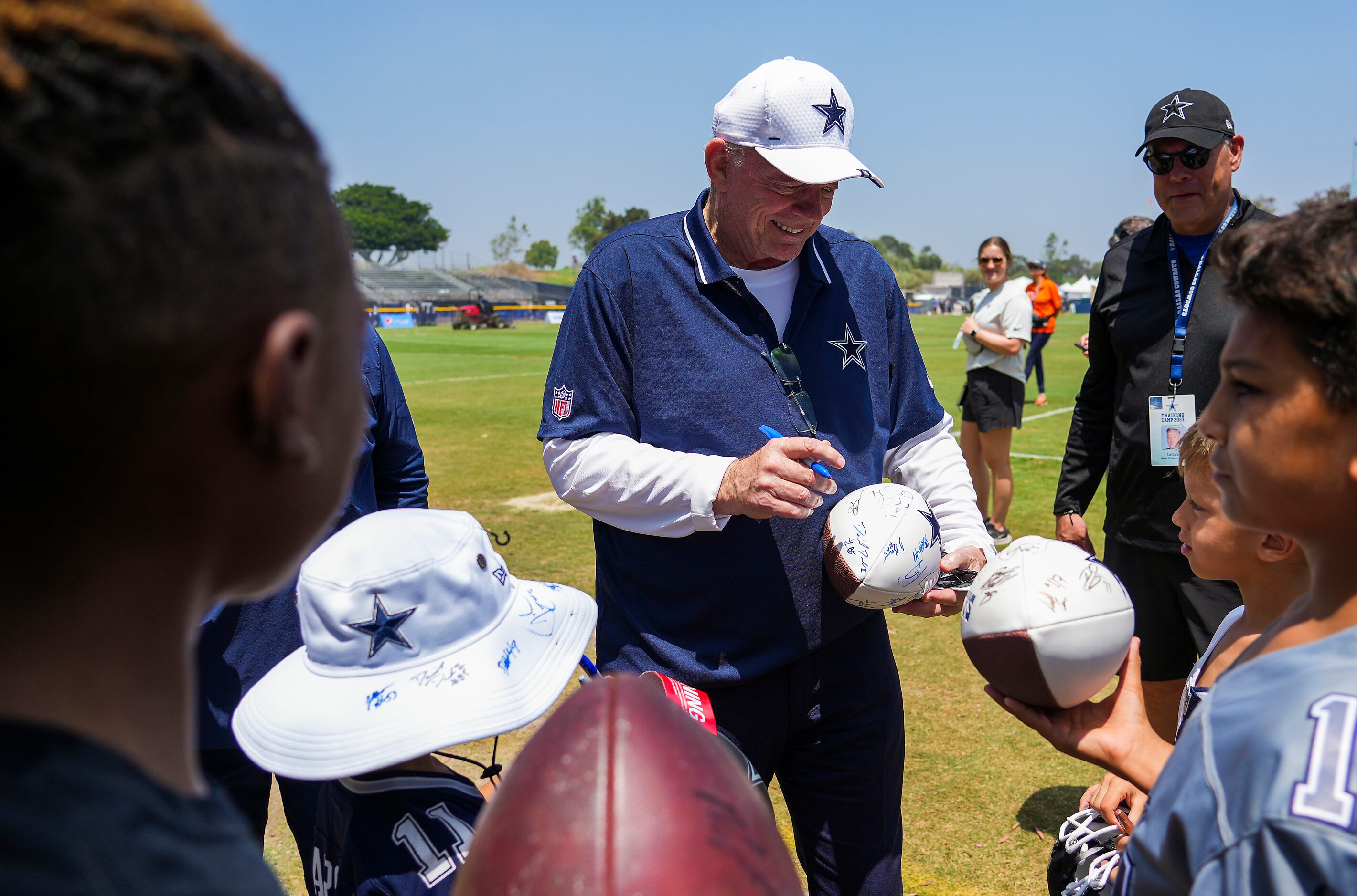 Dallas Cowboys owner and general manager Jerry Jones signs autographs after a training camp...