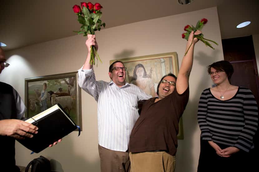 Newlyweds Gregory Enke, left, and Ariel Ulloa celebrate after the Supreme Court decided to...
