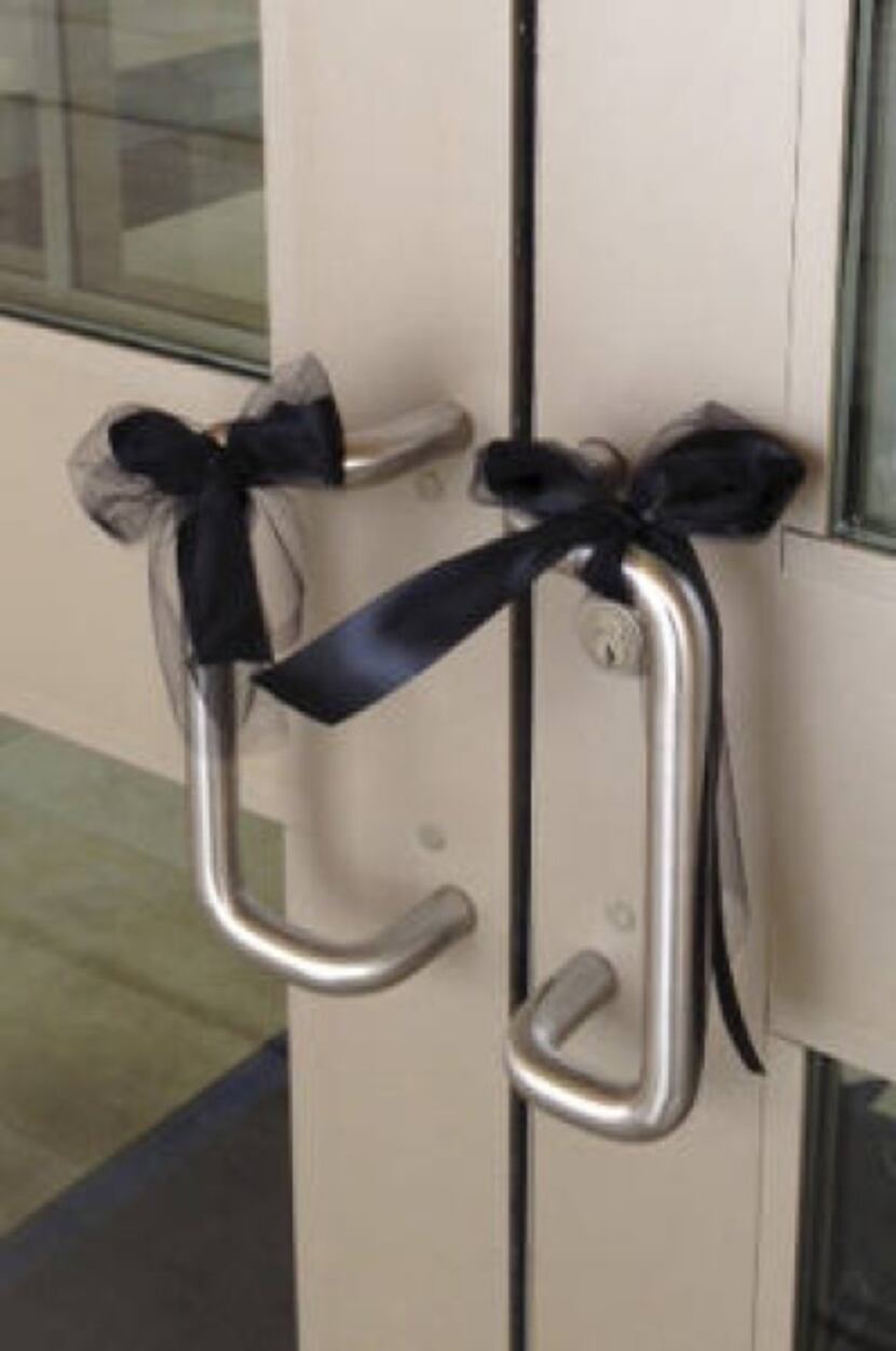 Black ribbons adorn the entrance doors to Byron Nelson High School, where students and...