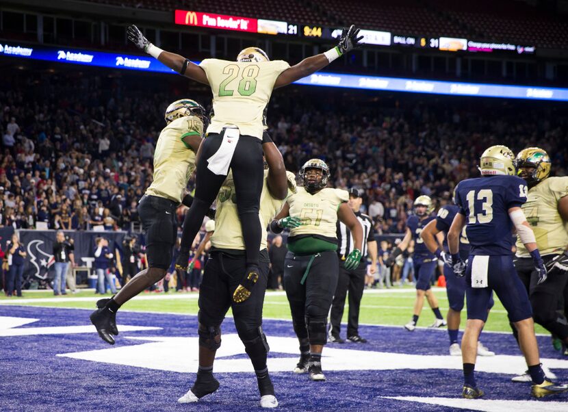 DeSoto running back Richie Washington Jr. (28) celebrates with Orion Smith (15) and ...