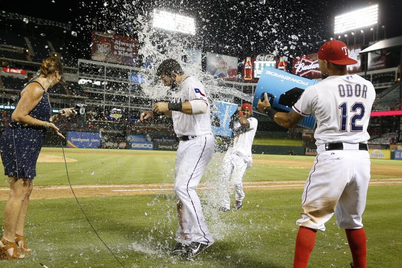 Texas Rangers first baseman Mitch Moreland (18) gets hit with water by teammates after...