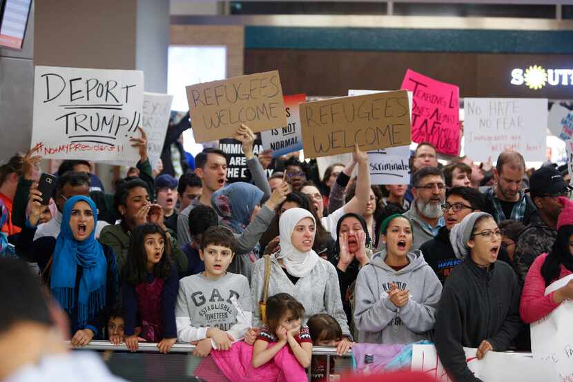Protesters gathered at DFW International Airport to denounce President Donald Trump's...