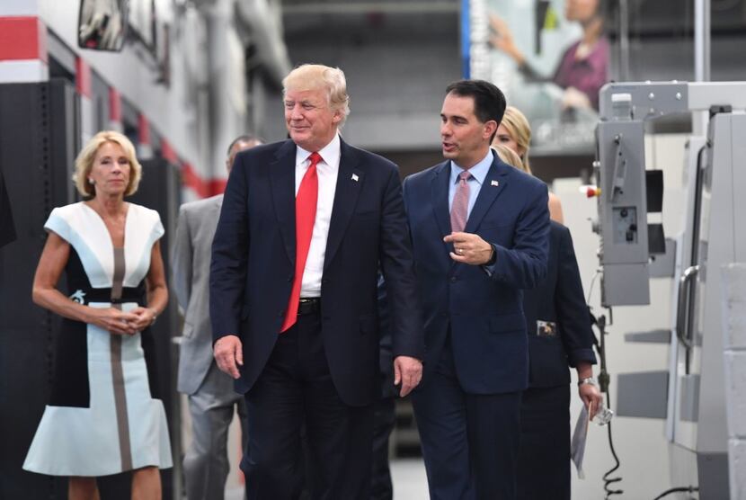 President Donald Trump and Wisconsin Gov. Scott Walker share a moment before a workforce...