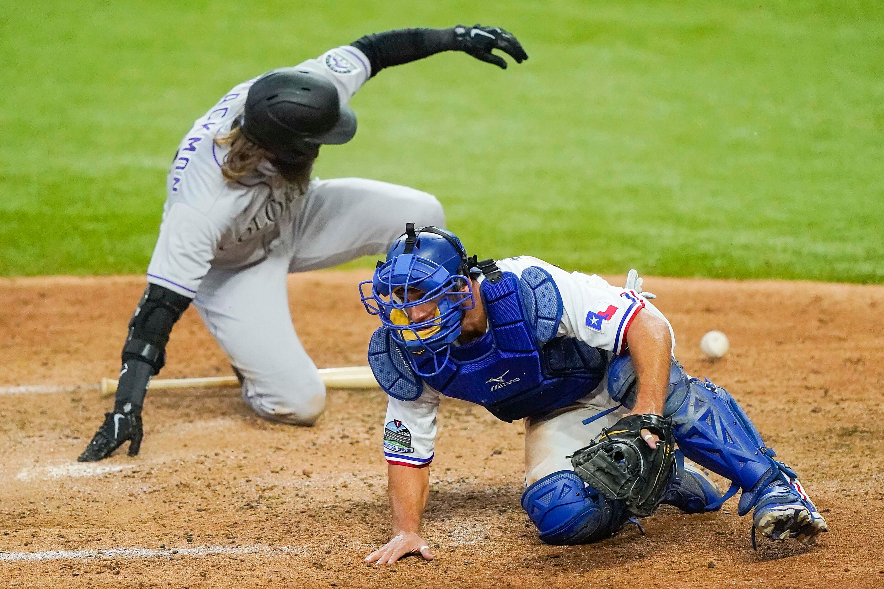 Colorado Rockies outfielder Charlie Blackmon is safe at home as the ball gets away from...