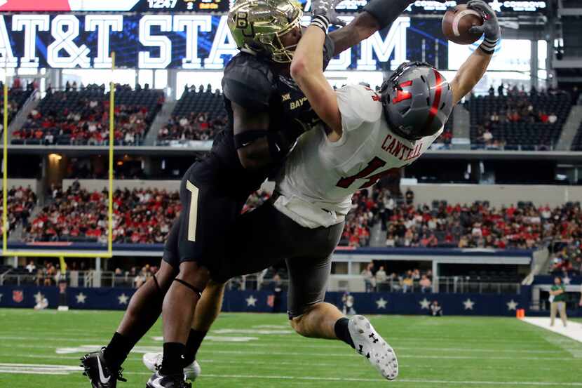 Texas Tech wide receiver Dylan Cantrell, right, tries to catch the ball against Baylor...
