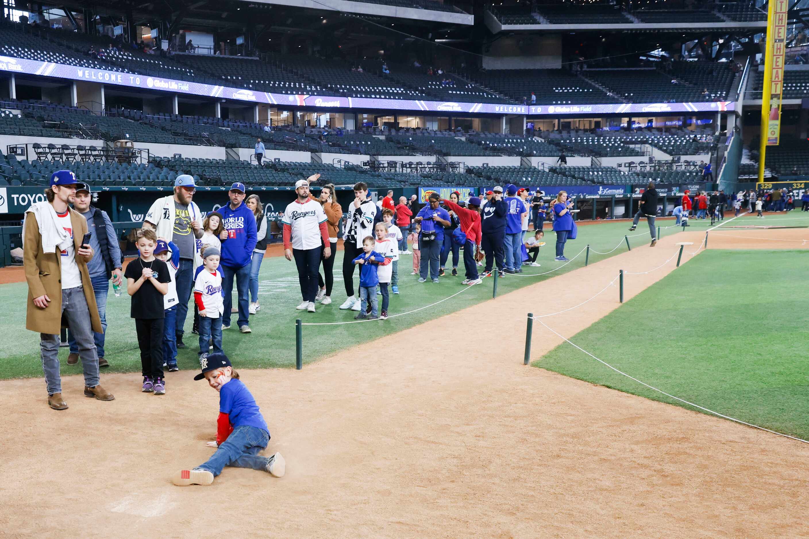 Fans stand in line to take a photo at the home plate during Texas Rangers Fan Fest on,...