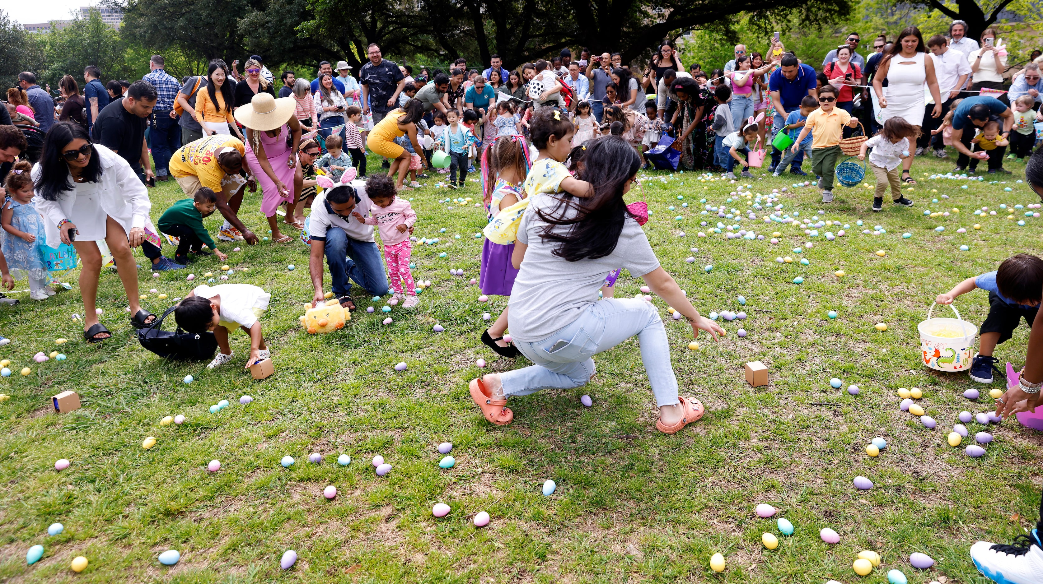 Children (and parents) scramble to collect Easter eggs during a hunt at Easter in Turtle...