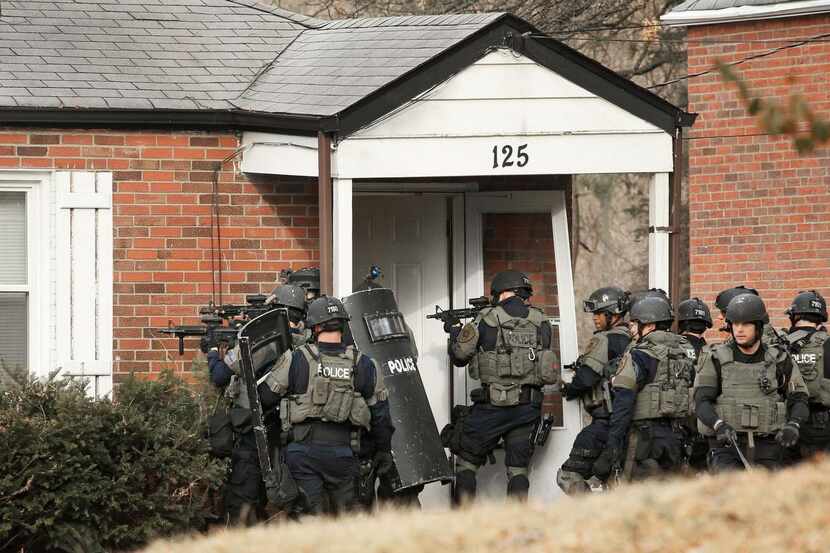 
A police tactical team prepared to enter a home in Ferguson, Mo., as they searched for a...