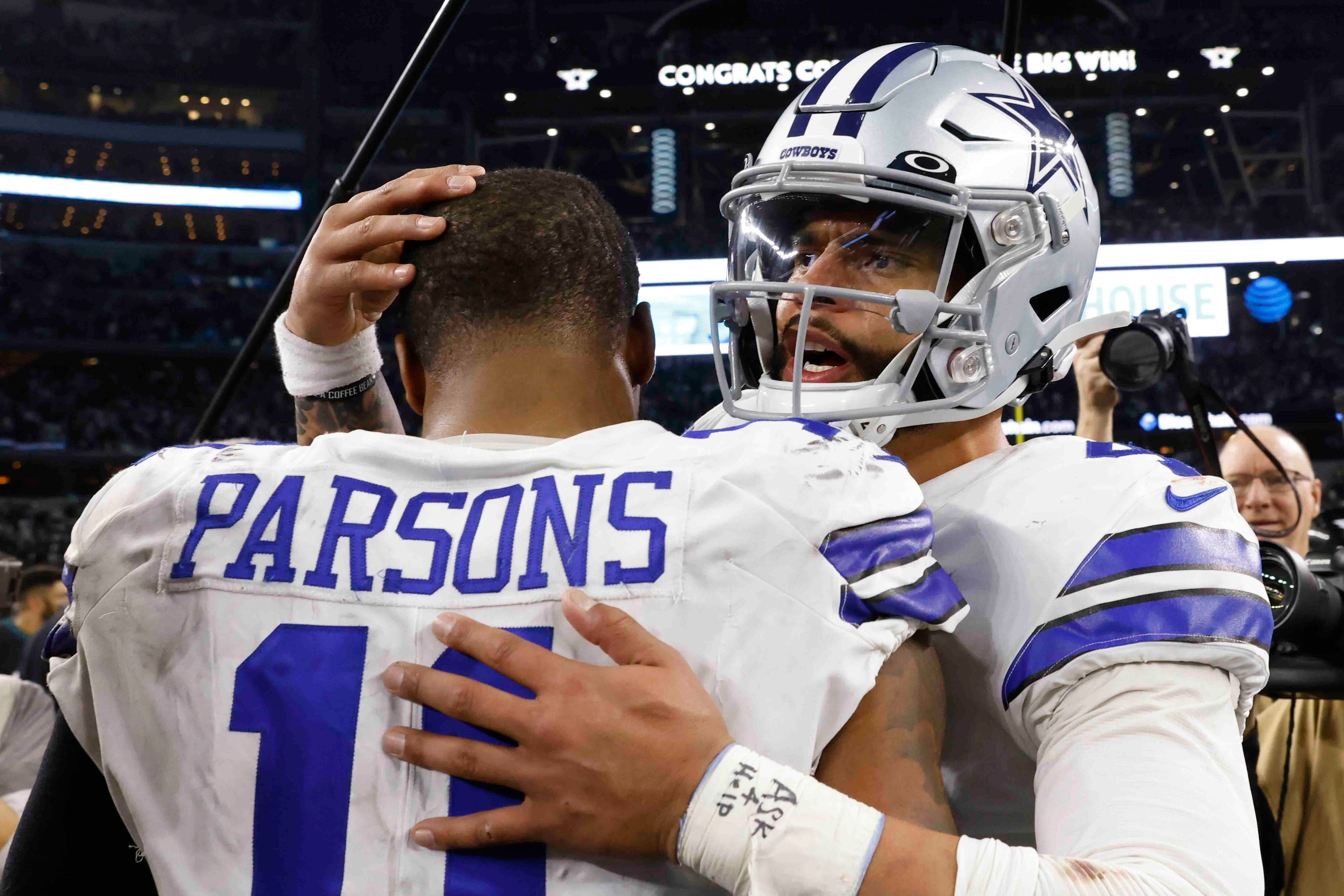 Dallas Cowboys quarterback Dak Prescott (4), right, hugs with Dallas Cowboys linebacker...