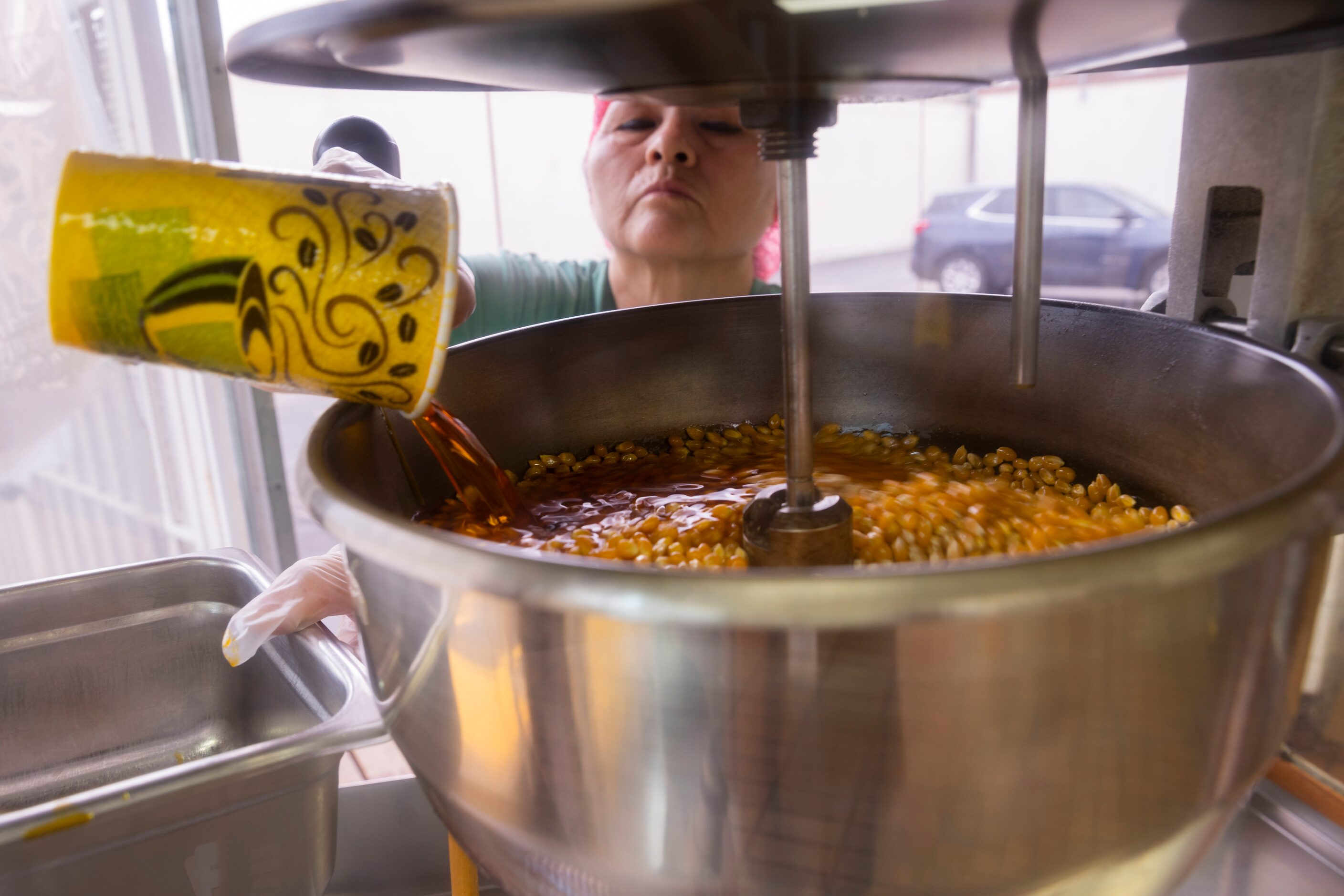 Maria Mendoza, who has been working at Lone Star Donuts for over 30 years, adds butter to...