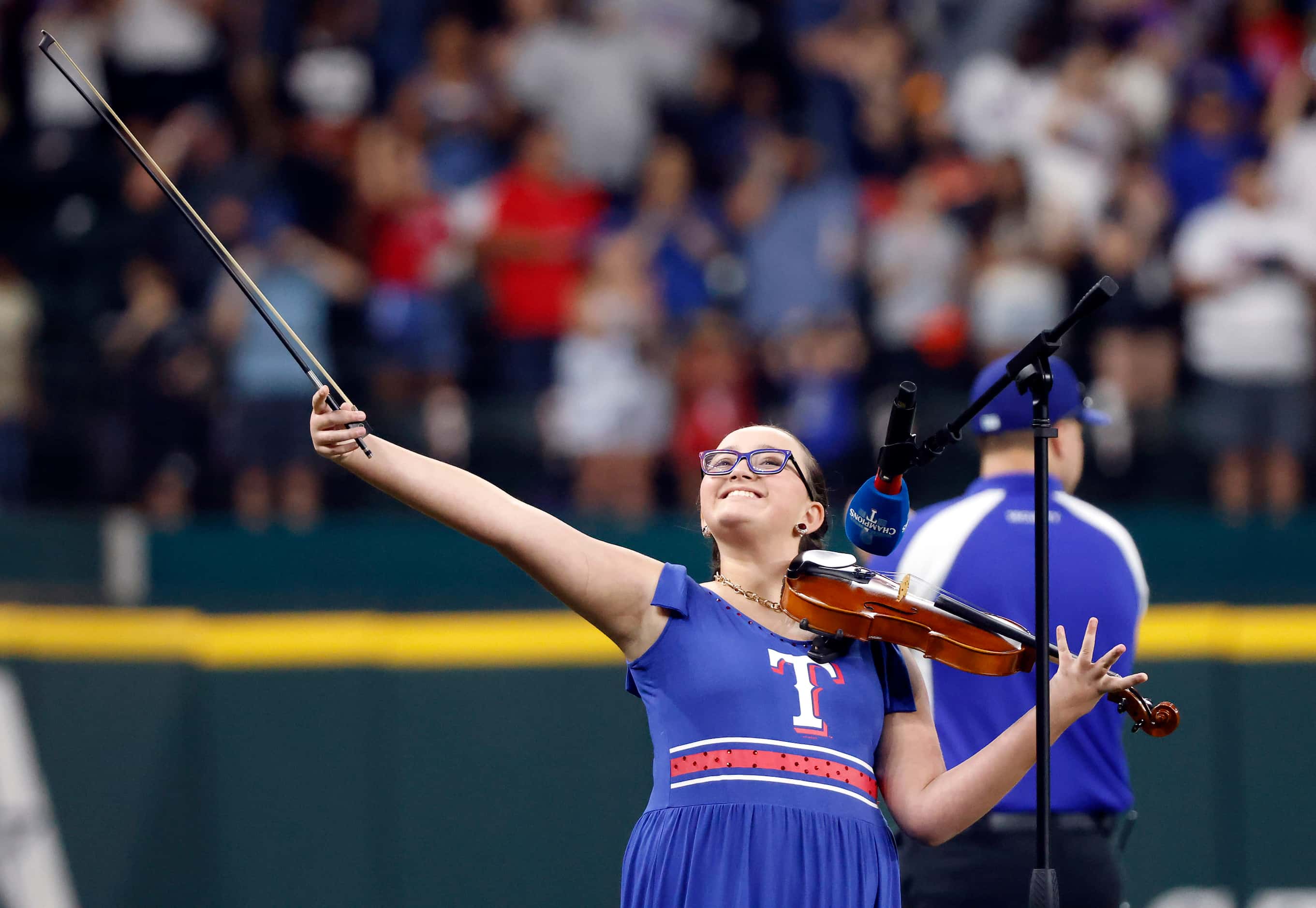 Violinist Sabrina Patel raises her bow after finishing God Bless America during the Texas...